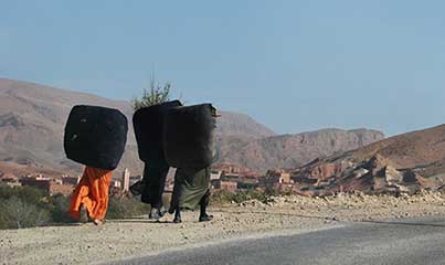 Vallée des roses - Femmes transportant de volumineux sacs d'herbes.
